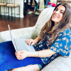 Photo of lifestyle influencer Sara Funk, smiling and working on a laptop